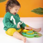 A Bright Starts Safari Beats musical drum toy featuring three colorful drums with lights, designed for babies aged 3 months a