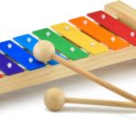 MUSICUBE wooden xylophone for kids with eight colorful metal keys and two wooden mallets on a light wood base.