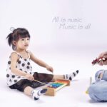 MUSICUBE wooden xylophone for kids with eight colorful metal keys and two wooden mallets on a light wood base.