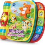 A red VTech Musical Rhymes Book, open to a colorful page with interactive elements and piano keys.
