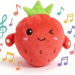 A soft pink strawberry plush toy with embroidered features, designed for sensory and musical play with babies and toddlers.